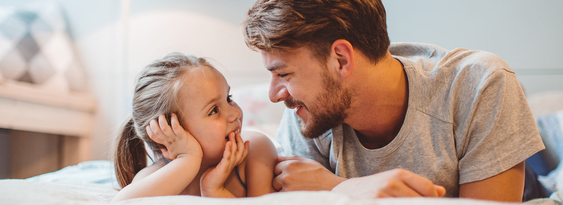 Dad and daughter smiling at each other