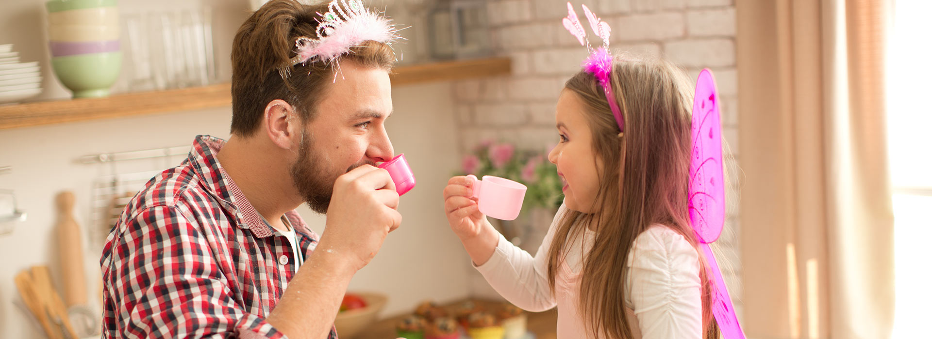 Little girl and dad dressed up drinking tea