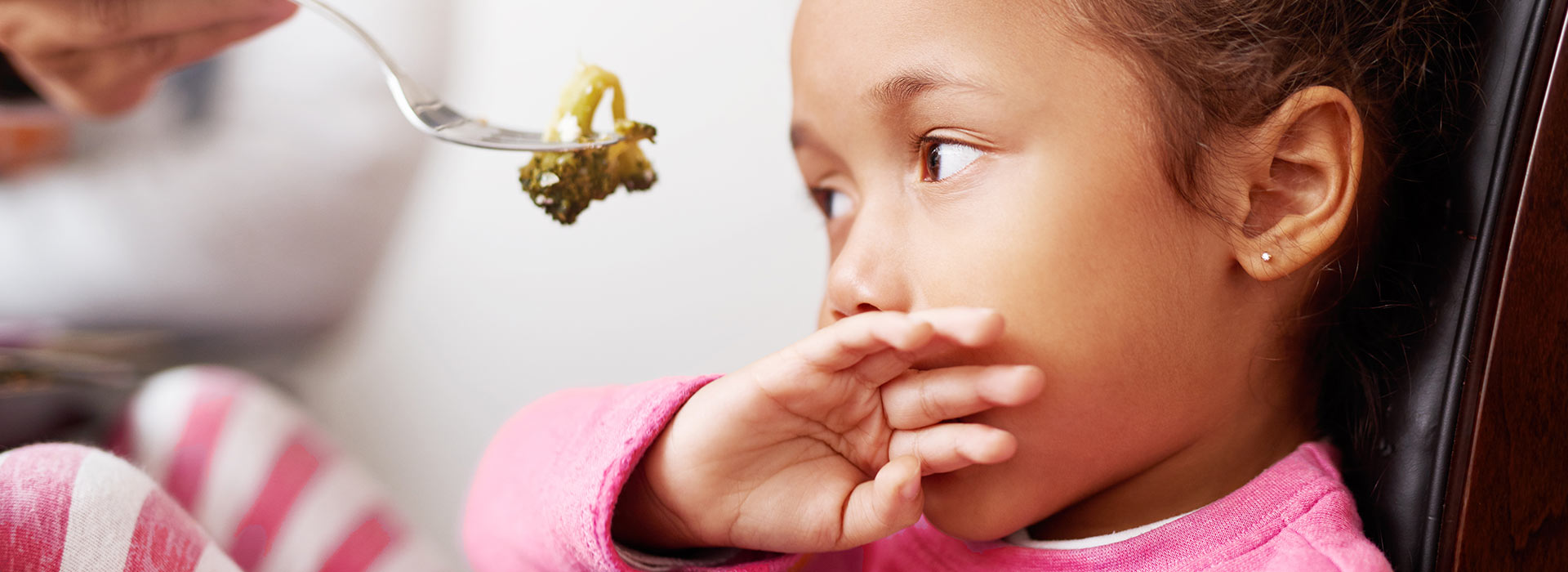 Little girl refusing to each vegetable