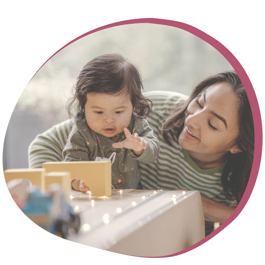 Mother plays with baby on fuschia background