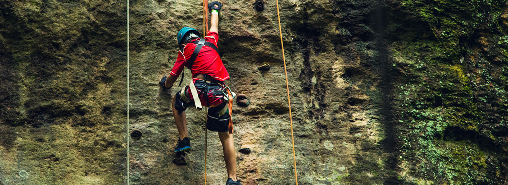 Boy climbing rock wall