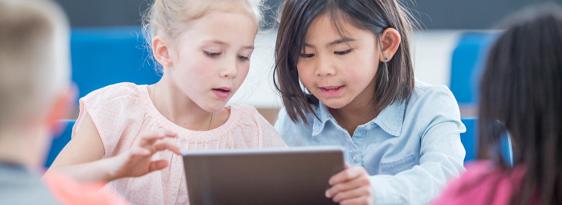 Two young girls using a tablet together