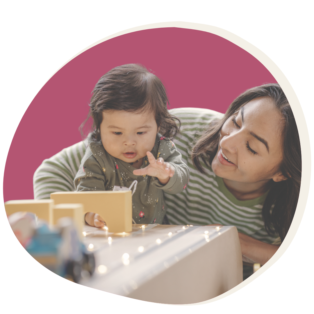 Mother plays with baby on fuschia background